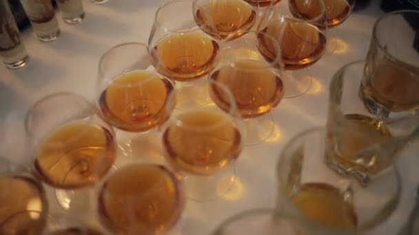 Вид зверху окуляри з різними алкогольними напоями на столі на весільному прийомі — стокове відео