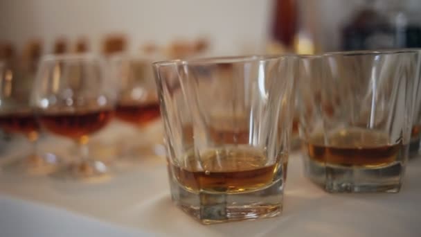 Diferentes bebidas alcohólicas en copas y copas de vino en mesa buffet de bodas — Vídeo de stock