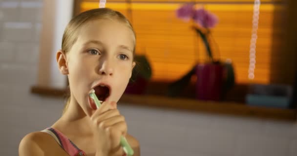 Little cute girl wearing pink pyjama brushing her teeth — Stock Video