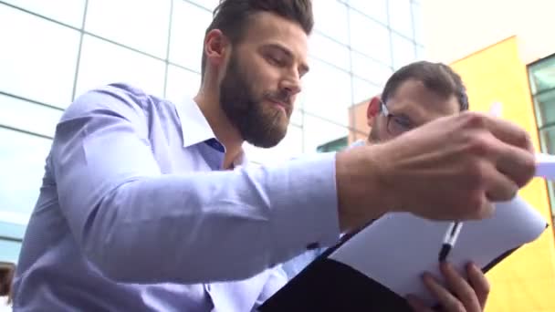 Two young businessmen talking in the street. — Stock Video