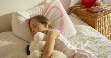 Onu oyuncak ile yatakta sevimli şirin kız kirlenmiş