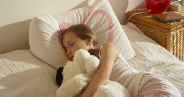Schattig leuk wakker meisje in het bed met haar speelgoed — Stockvideo