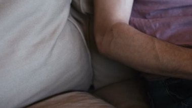 Dizüstü bilgisayar ile çalışma ve evde koltukta oturan insanın yakın çekim