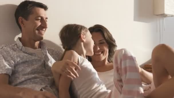 Portrait of cheerful couple playing with daughter on bed at home — Stock Video