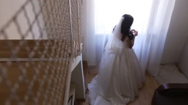 Pencere arka plan otel odasında yakınındaki poz şık lüks güzel esmer gelin. Gelin buketi ile. Üstten Görünüm.