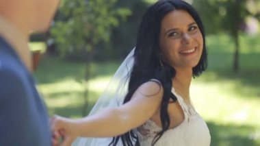 Parkta bir yürüyüş sırasında bir şirin esmer gelin damat izler