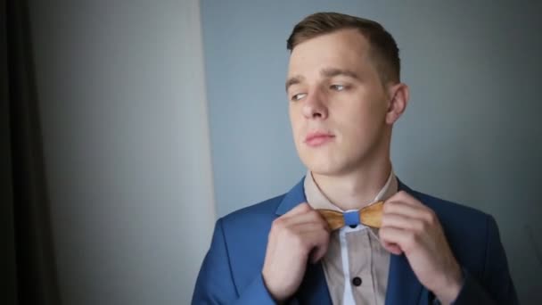 Närbild av en gentleman rätar hans trä bowtie. — Stockvideo