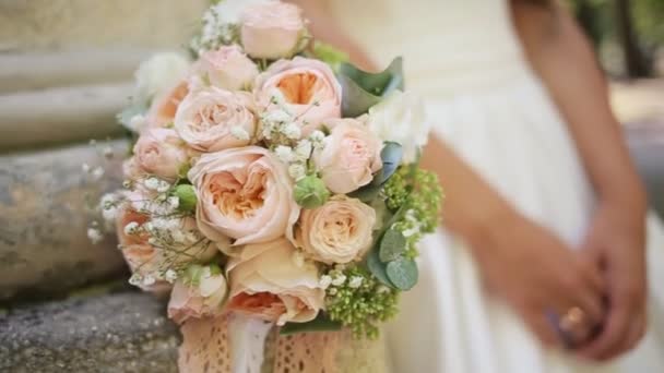 Buquê de casamento rosa e branco de rosas e mãos da noiva com anel de casamento — Vídeo de Stock