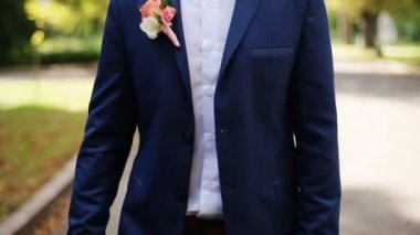 Yakışıklı genç adam ceketinin düğmeleri ve güneşli gün doğa üzerinde yürüme