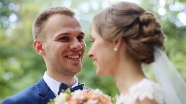 Gelin ve damat ile gelin buketi açık havada poz onların düğün günü gülümseyen mutlu