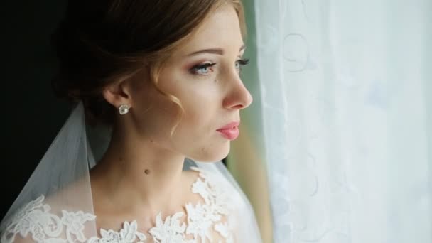 예쁜 신부 창 밖으로 보이는 그녀의 결혼 날에 웃 고 — 비디오