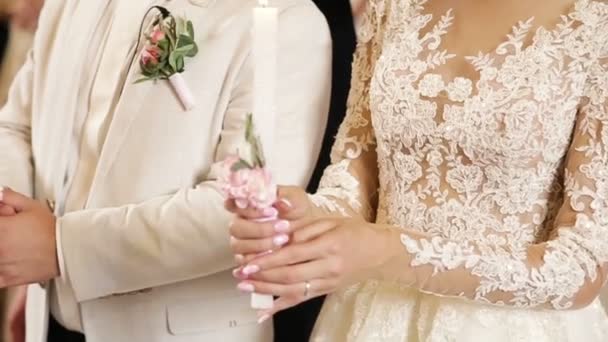 Young couple in the church holds wedding candles — Stock Video