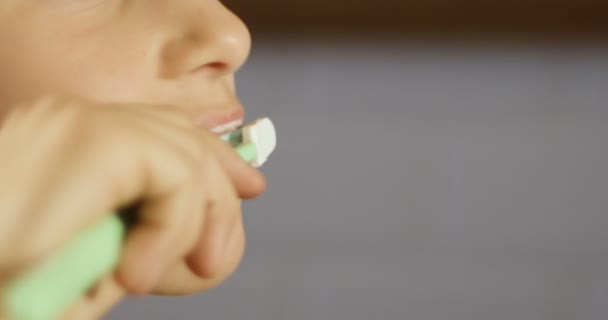 Una niña sonriente cepillándose los dientes en el baño. Hermoso niño sano en casa cepillarse los dientes y prepararse para la cama. Primer plano. . — Vídeos de Stock