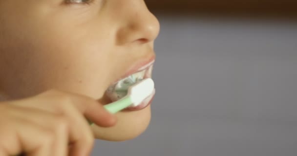 Glimlachend weinig meisje poetsen tanden in de badkamer. Mooi gezond kind thuis tanden poetst en maak je klaar voor bed. Close-up shot. — Stockvideo