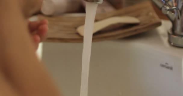 Närbild av barnen handen under ström av vatten i badrum i slow motion — Stockvideo