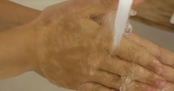 Close-up van kinderen hand onder stroom van water in de badkamer in slow motion — Stockvideo