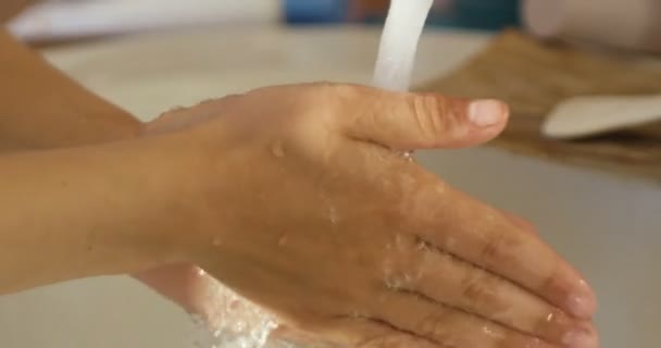 Close-up van kinderen hand onder stroom van water in de badkamer in slow motion — Stockvideo