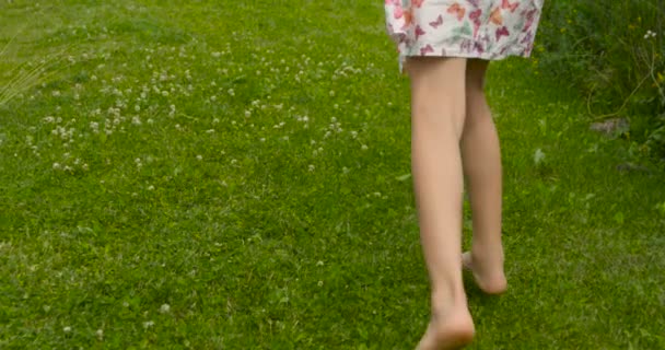 Cámara siguiendo dulce chica en vestido rosa huyendo en el jardín — Vídeos de Stock