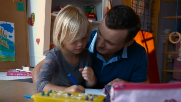 Young father and son drawing with colored pencils on the nursery table — Stock Video