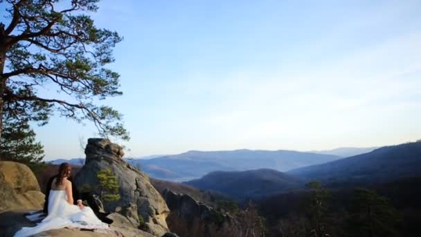 Piękny Fantastyczny szczęśliwy narzeczeni stylowe siedzi na tle słoneczne przepiękne góry — Wideo stockowe
