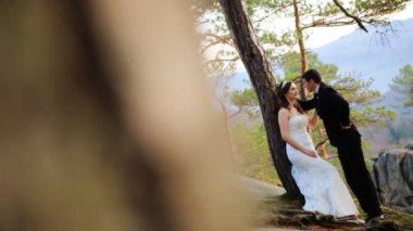 Çam ormanı içinde onun yakışıklı damat bakarak bir ağacına yaslanmış mutlu esmer gelin