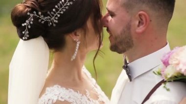 Mutlu yeni evli gelin ve damat öpüşme, onlar artık evliyiz fark. Açık yaz park ile arka plan olarak vurdu.