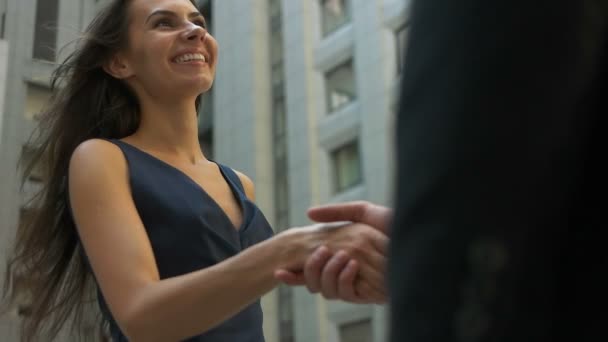 Negocio, asociación, éxito, gesto y concepto de la gente - hombre de negocios sonriente y mujer de negocios estrechando la mano en la calle de la ciudad — Vídeos de Stock