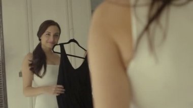 Giyim, dolap, moda, stil ve insanlar kavramı - askı, ayna evde siyah elbise ile mutlu esmer kadın