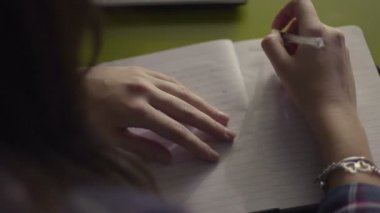 Günlüğüne yazma ve smartphone--dan müzik oldukça esmer genç kadının Üstten Görünüm
