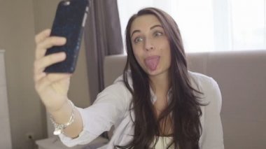 Güzel esmer oturma odasında evde kendini bir resim çekerek onu kanepede oturan