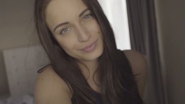 Sevimli esmer kadın bir selfie yapma ve yatak odasında eğlenmek
