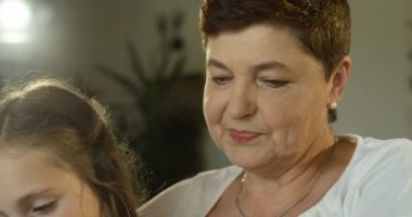 Sevimli kız dedesi kucağında oturan ve mutlu birlikte bir fotoğraf albümü bakarak