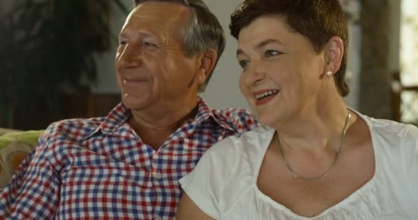 Aimer soigner couple âgé relaxant à la maison assis sur le canapé regarder la télévision. Mature mari et femme passer du temps ensemble — Video