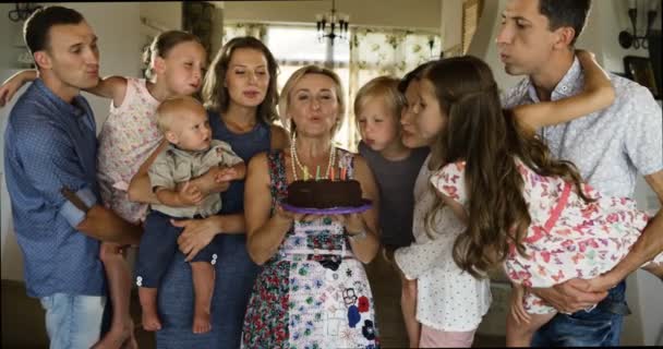 Több generációs család ünnepli születésnapját otthon, Elfújta a gyertyákat születésnapi torta — Stock videók