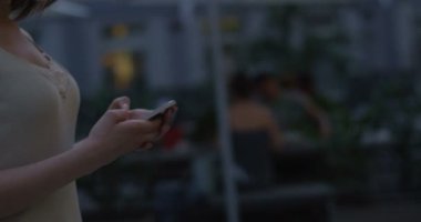 Smartphone-e doğru metin mesajı kullanarak eller yürüyen genç kadın