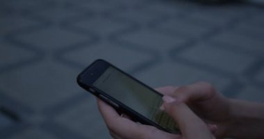 Smartphone-e doğru metin mesajı kullanarak eller yürüyen genç kadın