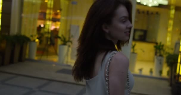 Портрет молодой счастливой женщины в городе на улице — стоковое видео