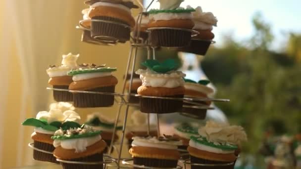 Mesa de casamento com doces e bolos, doces de doces, mesa de chá, doces bar chocolate doces feriado para crianças e um dente doce - bolo de casamento delicioso e bonito — Vídeo de Stock