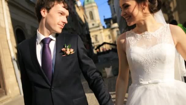 couple nouvellement marié marcher ensemble tenant les mains tiré au ralenti gros plan 