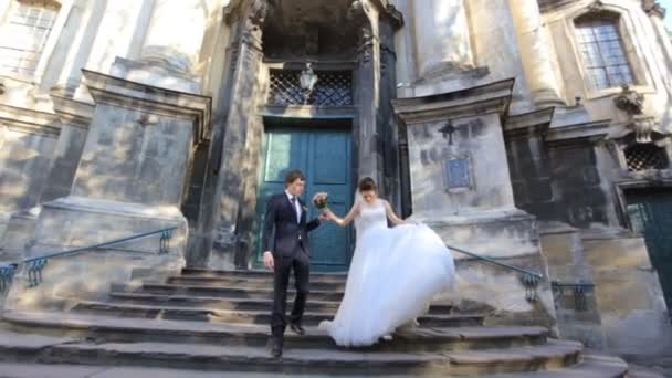 La sposa e lo sposo bella giovane coppia che si tiene per mano camminando girato al rallentatore da vicino — Video Stock