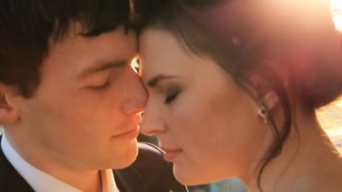 Güzel genç çift gelin ve damat bir gelinlik güneşin birbirine mutlu aile, öpüşme şefkatle bakarak seviyorum