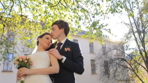 Красива молода пара наречена і наречений стоять в парку і обіймають один одного стрілянина в повільному русі крупним планом — стокове відео