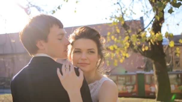 Sensuale bella giovane sposa bionda e bello sposo abbraccio al tramonto nel parco primo piano girato al rallentatore primo piano — Video Stock