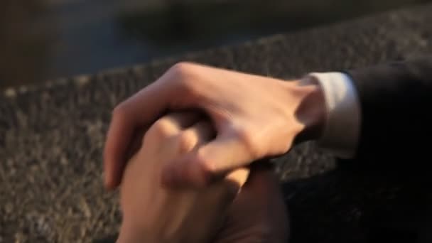 Manos suavemente conectadas de una pareja de recién casados con anillos de boda en un disparo de dedo en cámara lenta de cerca — Vídeos de Stock