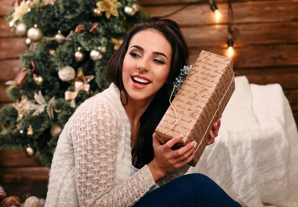 Podekscytowany młoda kobieta z Boże Narodzenie obecny pudełko z przodu choinki — Zdjęcie stockowe