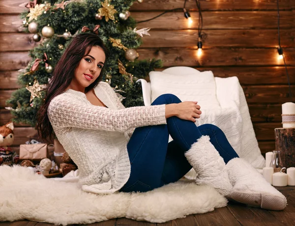Chica alegre sentado en el árbol de Navidad piso y regalos . — Foto de Stock