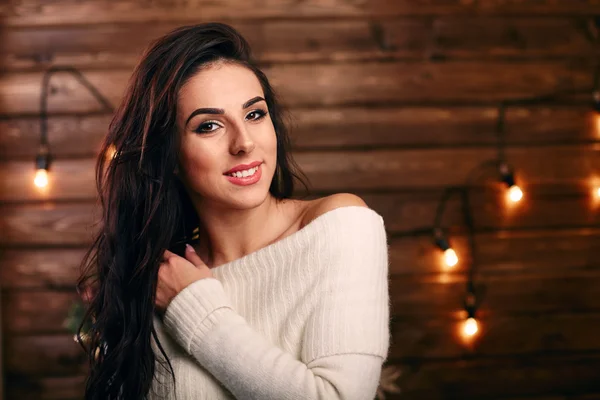 Retrato de mujer hermosa en casa fondo de madera y luces en la pared — Foto de Stock