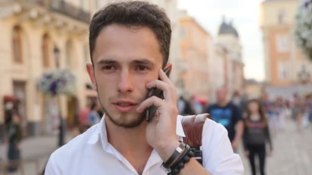 Člověk vést konverzaci na telefonu venku ve zpomaleném filmu. Student na mobil uprostřed Evropské město. — Stock video