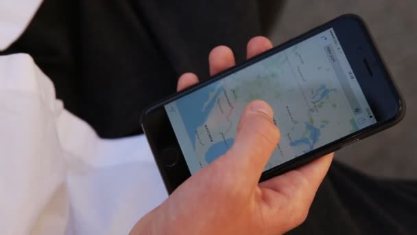 Közeli kép a fiatal férfi kezét, maps-ra smartphone görgetés — Stock videók