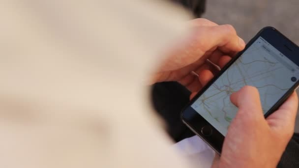 Gros plan de jeunes mains masculines zoomant cartes sur smartphone pour trouver l'emplacement — Video